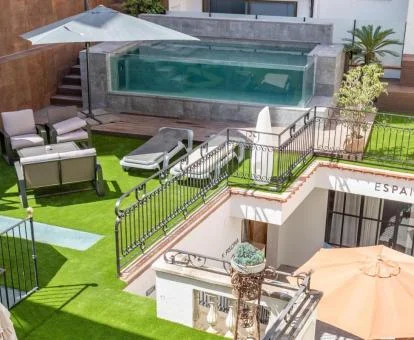 Agradable espacio exterior con mobiliario y piscina de este hotel boutique.