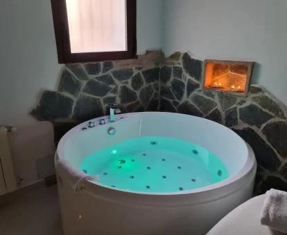 Coqueto rincón con jacuzzi privado y sofá Tantra del apartamento.