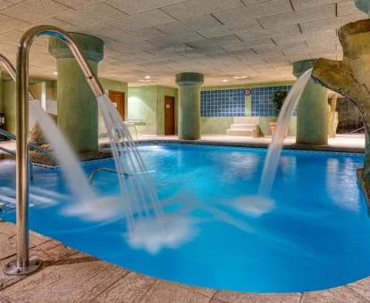 Piscina cubierta con elementos de hidroterapia del spa del hotel.