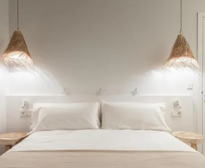 Una de las coquetas habitaciones del hotel con colores claros y madera natural.