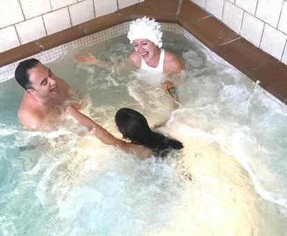 Varias personas disfrutando de la zona de hidroterapia del spa.