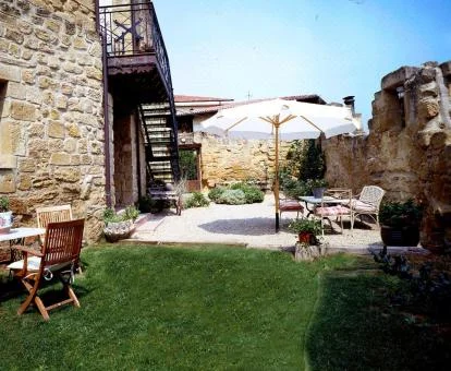 Zona exterior con jardín y mobiliario de este hotel con encanto.