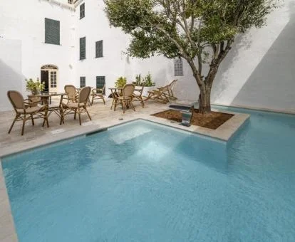 Zona exterior con mobiliario y piscina al aire libre de este hotel boutique.