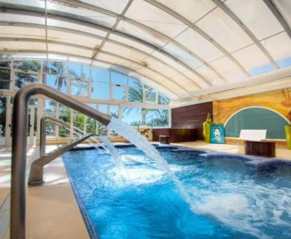 Preciosa piscina cubierta con chorros de hidroterapia del spa del hotel.