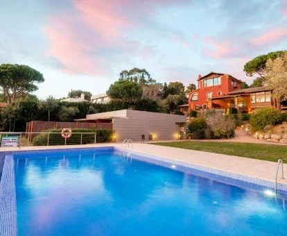 Hotel rural con piscina al aire libre rodeado de vegetación.