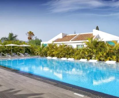 Edificio de este hotel exclusivo para hombres con piscina exterior rodeado de jardines.