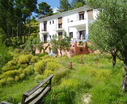 Precioso hotel rural rodeado de naturaleza con zonas de estar en el exterior.
