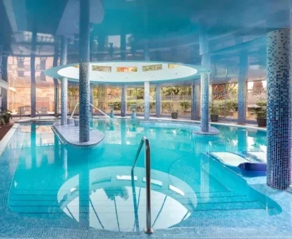 Espectacular piscina cubierta con hidroterapia y vistas al exterior del centro de bienestar del hotel.