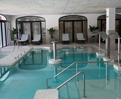 Piscina interior con elementos de hidroterapia del spa del hotel.
