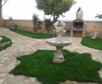 Terraza ajardinada con barbacoa de este hotel rural.