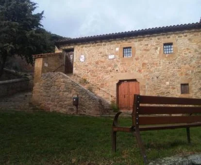 Casa rural independiente de piedra con zona exterior ajardinada.