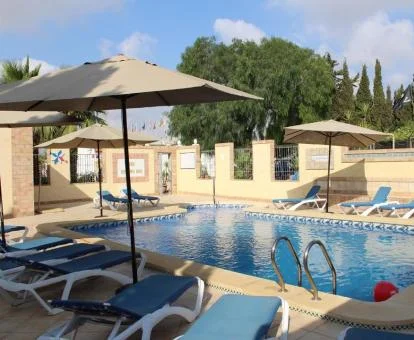 Zona exterior con piscina y mobiliario de esta preciosa finca rural.