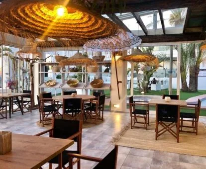 Comedor del hotel con acceso directo al jardín y vistas a la playa.