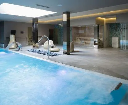 Piscina cubierta con elementos de hidroterapia del spa del hotel.