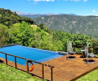 Hermosa piscina de borde infinito con espectaculares vistas a las montañas de este hotel rural.