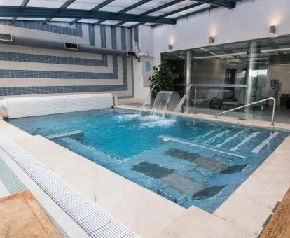 Piscina cubierta con elementos de hidroterapia del spa del hotel.