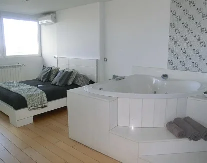 Elegante Suite con jacuzzi junto a la cama ideal para una escapada romántica con tu pareja por Madrid Foto del jacuzzi que se encuentra junto a la cama en la suite con bañera de hidromasaje en el bed and breakfast Syt Luxury