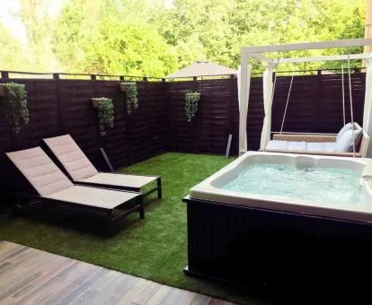 Terraza privada con un gran jacuzzi al aire libre de uno de los apartamentos.