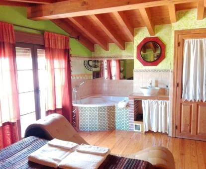 Dormitorio con sofá tantra y jacuzzi privado de este coqueto apartamento para parejas.