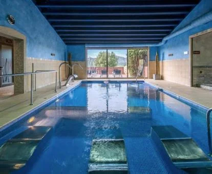 Gran piscina interior con camas de agua del spa del hotel.
