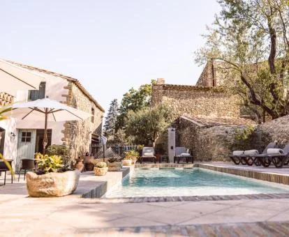 Hermoso hotel boutique con amplia zona exterior con mobiliario y piscina.