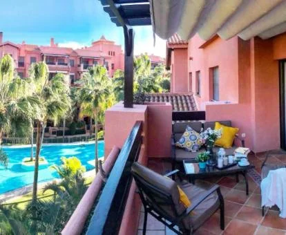 Fabulosa terraza con vistas a la piscina del complejo de este apartamento con jacuzzi privado.