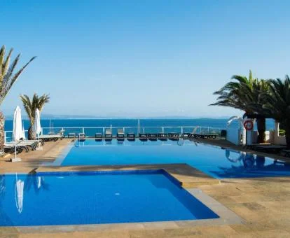 Amplias piscinas exteriores con vistas al mar del hotel.