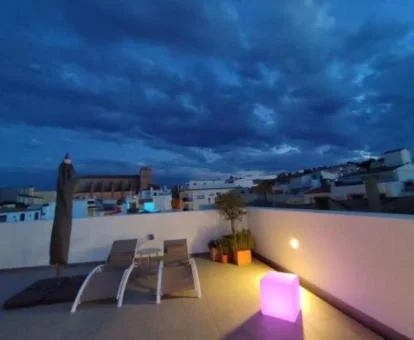 Terraza solarium del hotel con tumbonas, iluminación nocturna y preciosas vistas.