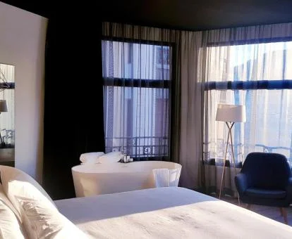 Una de las modernas habitaciones con vistas y bañera cerca de la cama del hotel.
