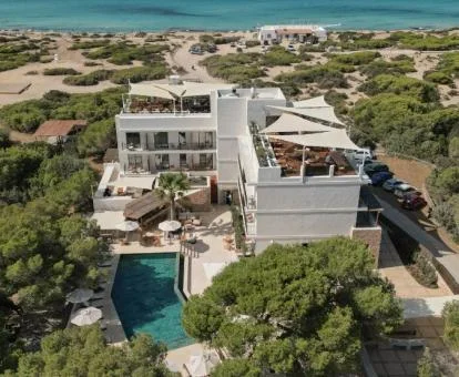 Precioso hotel rodeado de naturaleza a poca distancia a pie de la playa y con piscina exterior y zonas de estar al aire libre.