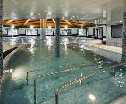 Gran piscina cubierta con elementos de hidroterapia del spa del hotel.