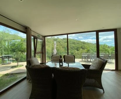 Zona de estar acristalada con terraza y espectaculares vistas a la naturaleza de uno de los apartamentos del complejo.