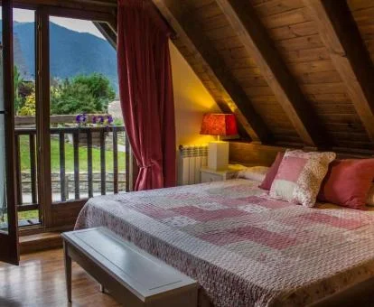 Una de las bellas habitaciones de estilo tradicional montañés con balcón y vistas de este hotel rural.