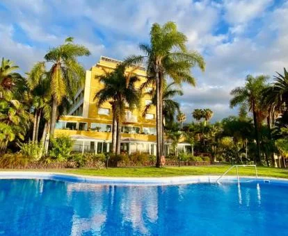 Hotel boutique con hermosos jardines de estilo tropical y piscina al aire libre.