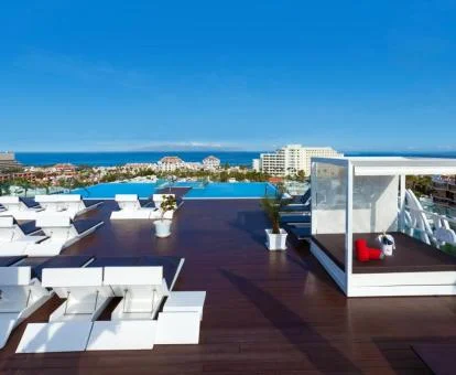 Terraza solarium con tumbonas, camas balinesas y una amplia piscina con vistas al mar de este hotel solo para adultos.