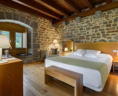 Una de las acogedoras habitaciones con paredes de piedra a la vista de este hotel rural.