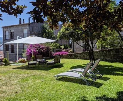 Edificio de este hotel rural con jardín y mobiliario al aire libre.