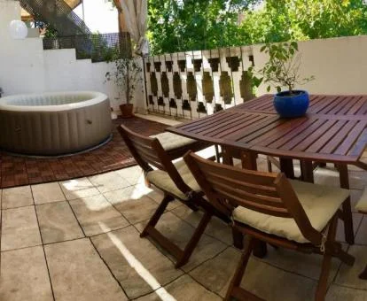 Terraza privada con mobiliario y jacuzzi al aire libre de este apartamento ático.