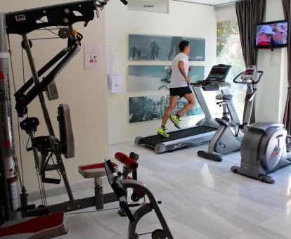 Hombre disfrutando de la sala fitness del spa del hotel.