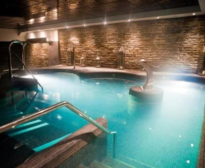 Piscina cubierta con elementos de hidroterapia del centro de spa del hotel.