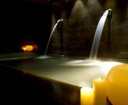 Acogedora zona de aguas del spa con iluminación relajante.