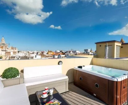 Preciosa terraza con jacuzzi privado y vistas a la ciudad de este luminoso apartamento.