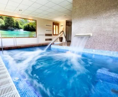 Piscina cubierta con hidroterapia de las instalaciones de spa del hotel.