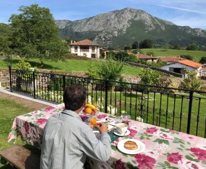 Un hombre disfruta de su desayuno en el jardín del hotel con preciosas vistas.