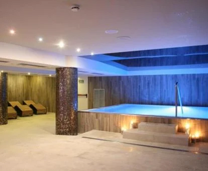 Elegante zona de bienestar del spa con piscina cubierta y zona de relajación.