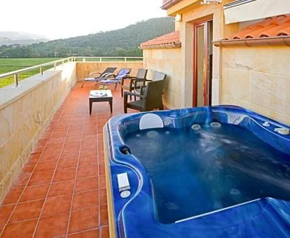 Preciosa terraza con jacuzzi privado al aire libre y maravillosas vistas a las montañas del apartamento superior de este establecimiento.