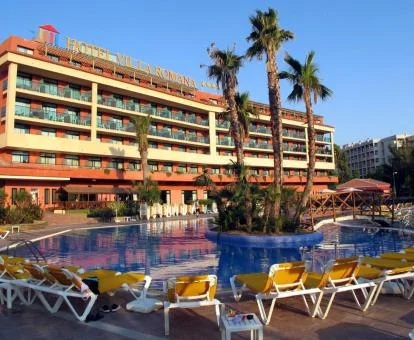 Hotel con encanto con piscina exterior rodeada de tumbonas.