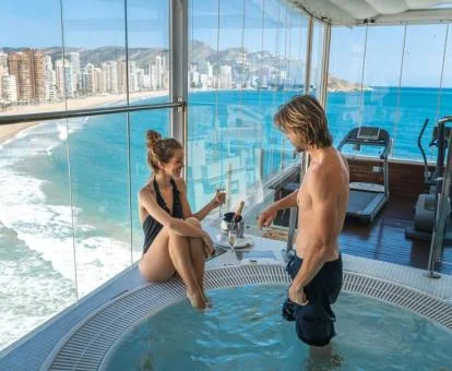 Pareja brindando en el spa de este espectacular hotel con bonitas vistas al mar.
