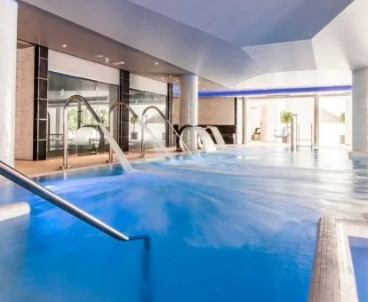 Piscina cubierta con elementos de hidroterapia del spa del hotel.