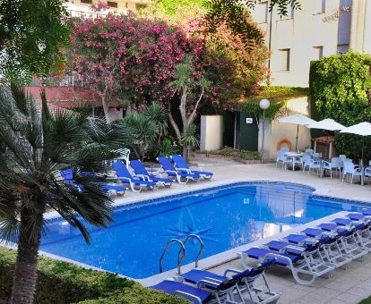 Hotel rural con amplia zona exterior con piscina rodeada de vegetación.